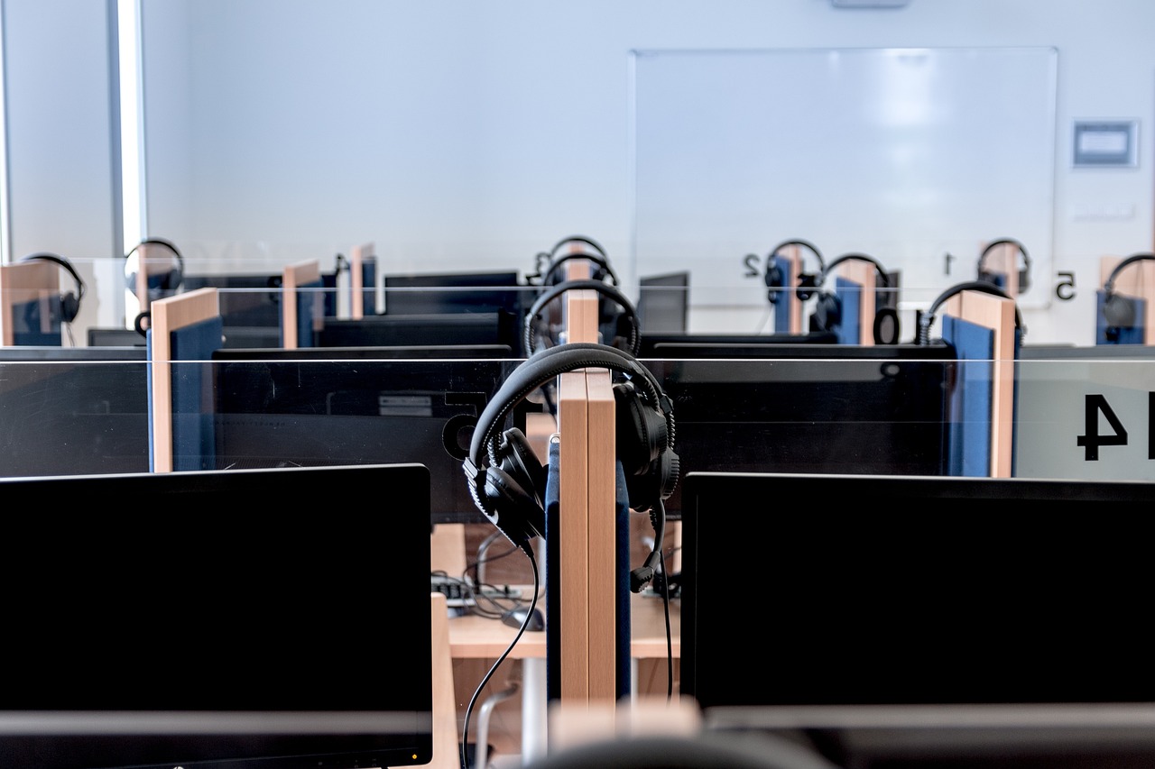 A row of desktop computers in a school computer lab
