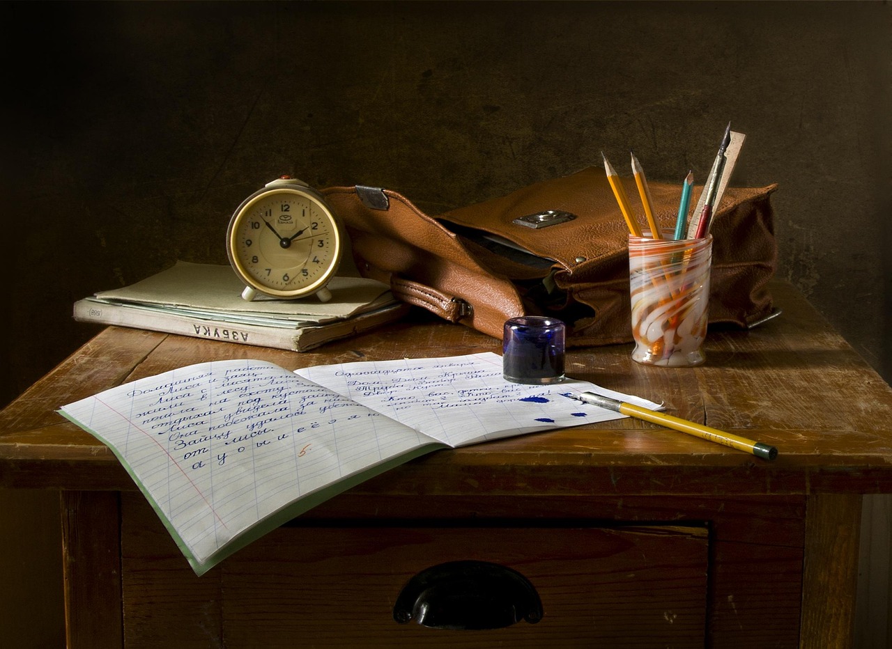 An open book and pencil resting on a desk