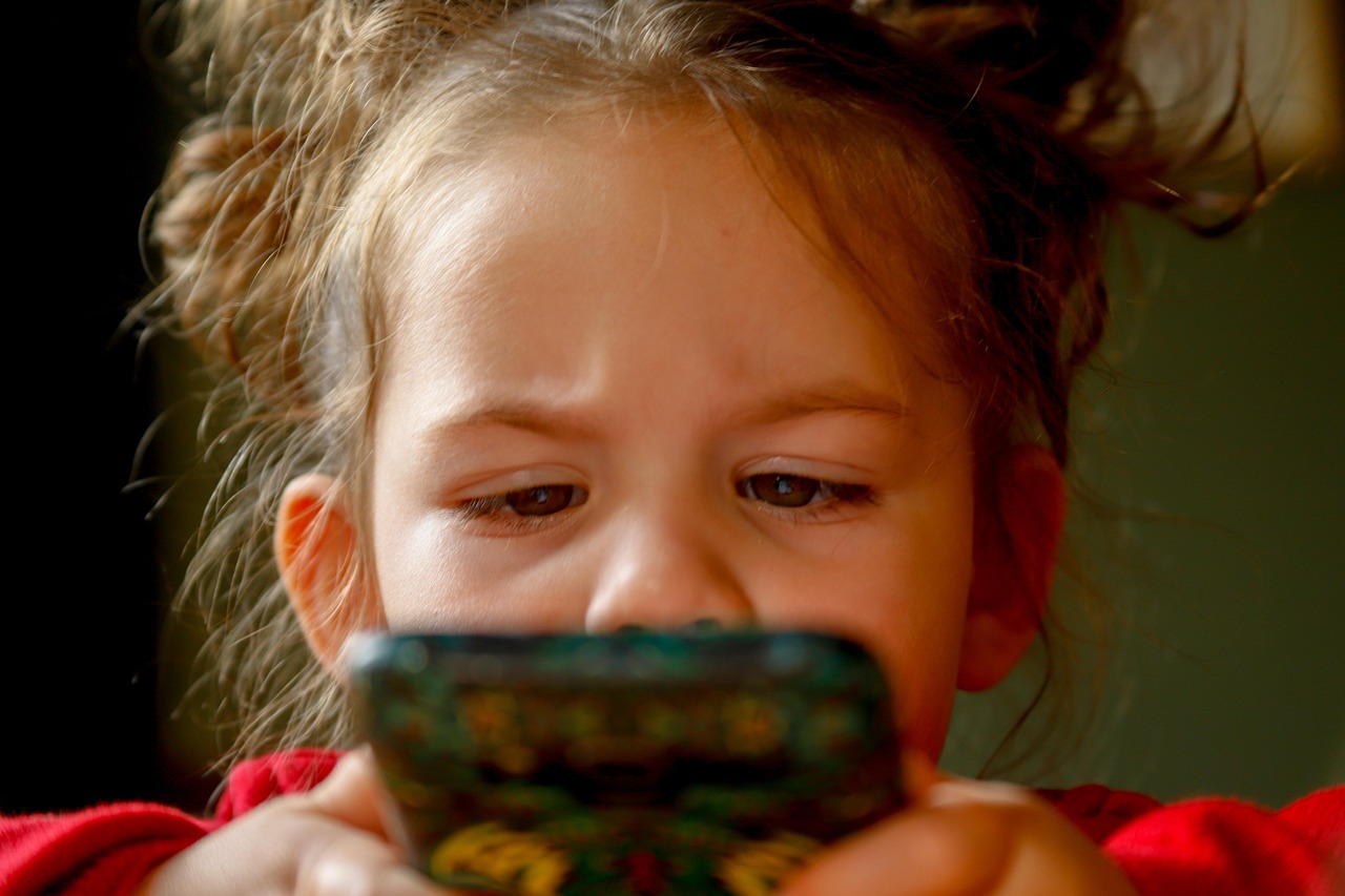 A child's hands holding a smartphone