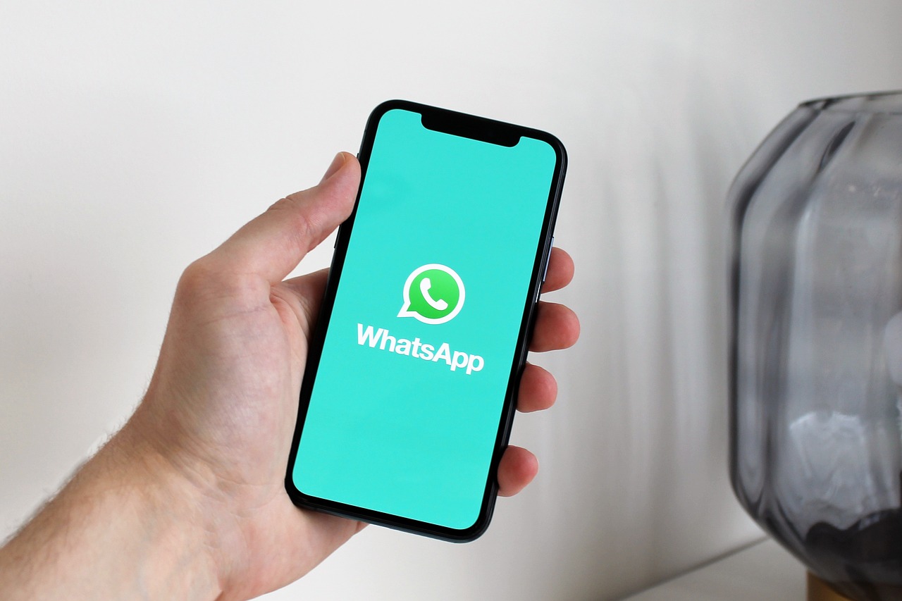 A person holding a smartphone with a messaging app open.