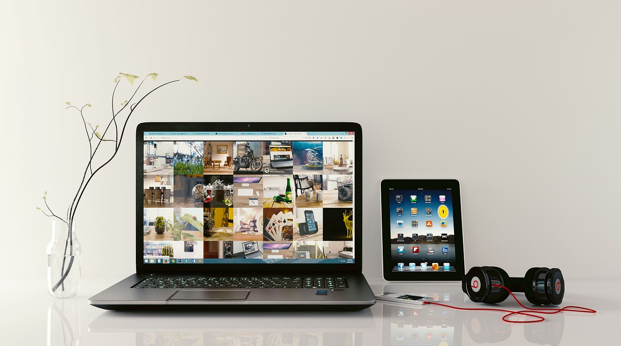 A child at a desk wearing headphones while working on a tablet